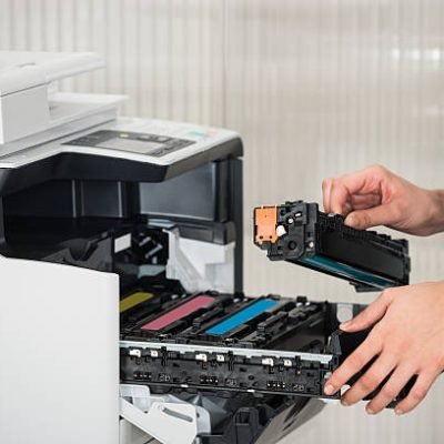 Midsection of young businessman fixing cartridge in printer machine at office